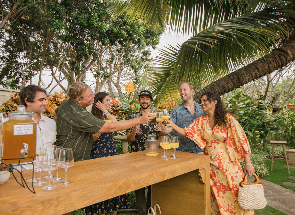 Guests toasting drinks at the garden bar under the palms